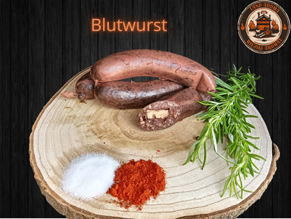 Rustic Blutwurst on wooden board with spices and rosemary, part of the 10 kg Königliche Box.